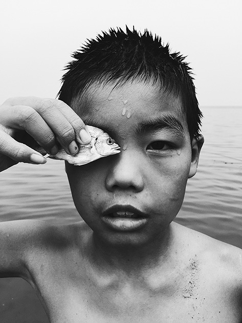 Второе место, номинация «Фотограф года»

«Я встретил этого мальчика во время прогулки по морскому побережью. Когда я попытался сфотографировать его, он приложил пойманную рыбу к своему глазу». 

Город Яньтай, провинция Шаньдун, Китай
Снято iPhone 6

