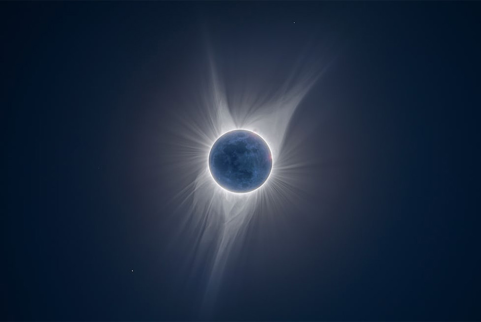 Во время солнечного затмения яркая солнечная корона скрывает детали поверхности Луны. На изображении видны спутники, которые освещены солнечным светом, отраженным Землей. 