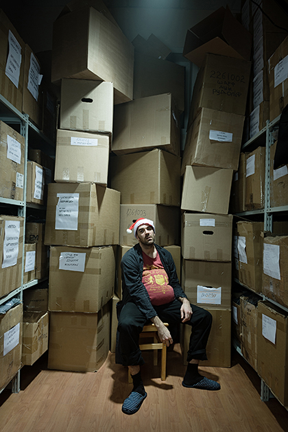 «Я часто бываю на складах, и каждый раз ряды коробок и паллет напоминают мне Кафку. Как Новый год может выглядеть для работника склада — ничего не меняется, коробки, стеллажи, погрузчики, и новогодняя шапочка». 