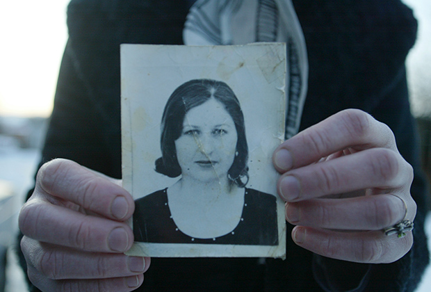 Подруга Эльзы Кунгаевой держит фотографию девушки, убитой Будановым. Село Танги-Чу