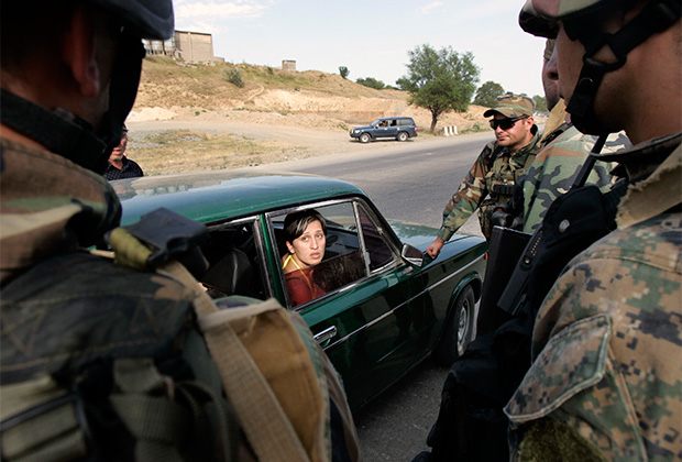 Грузинские военные проверяют машину беженцев, покидающих Гори. 13 августа 2008 года