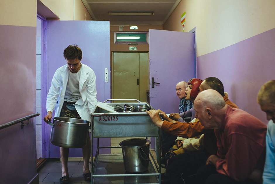 Санитар Геннадий несет кастрюлю с едой во время обеда в психоневрологическом интернате для престарелых и инвалидов № 3.