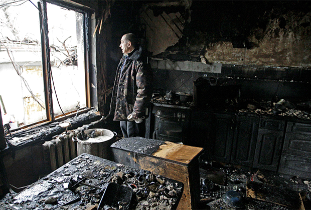 Житель Донецка осматривает свой дом, пострадавший в результате боевых действий