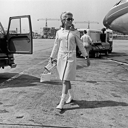 Катрин Денев в пальто от Андре Куррежа в лондонском аэропорту (1965)