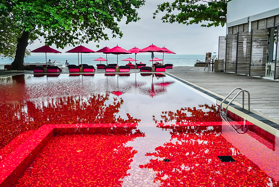 Еще один экзотический вариант — кроваво-красный бассейн в Таиланде, в курортном отеле The Library на острове Самуи. Вода не крашеная — потрясающий цветовой эффект создается за счет мозаики в оранжевых, желтых и красных тонах. Плюс красные зонтики по периметру — и вот он, бассейн из фильмов ужасов.
