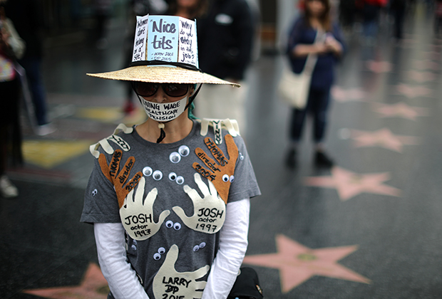 Активистка во время марша протеста против сексуальных домогательств. На ее одежде имена всех людей, которые когда-то ее домогались. Лос-Анджелес, США