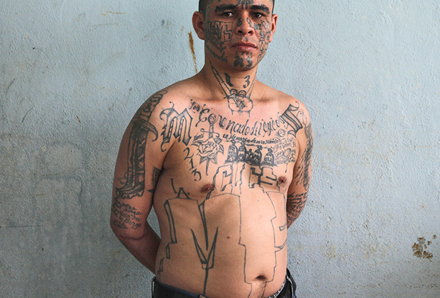 А вот спереди татуировки у Эль Ресио более привычные. Гангстер решил добавить образу немного сатанизма и набил на горло «козу».