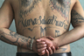 32-летний Эль Ресио — в прошлом глава одной из банд, входящих в Mara Salvatrucha, а ныне заключенный тюрьмы Комаягуа в Гондурасе, отбывающий пожизненный срок.  Доминирующее положение на теле чаще всего занимает название ОПГ. Эль Ресио добавил на спину ангельские крылья — не самая популярная у сальвадорских бандитов татуировка. 