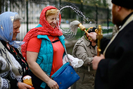 Священник окропляет верующих святой водой в Страстную пятницу. Славянск, Донецкая область Украины, апрель 2014 г.