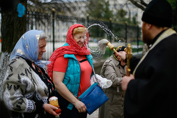 Священник окропляет верующих святой водой в Страстную пятницу. Славянск, Донецкая область Украины, апрель 2014 г.