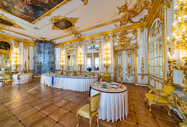 Один из залов дворца с печкой и накрытыми столами. 