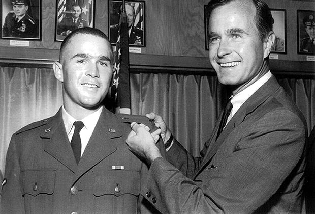 Джордж Буш-старший демонстрирует офицерские погоны второго лейтенанта Национальной гвардии США своего сына после присяги, 1968 год. 