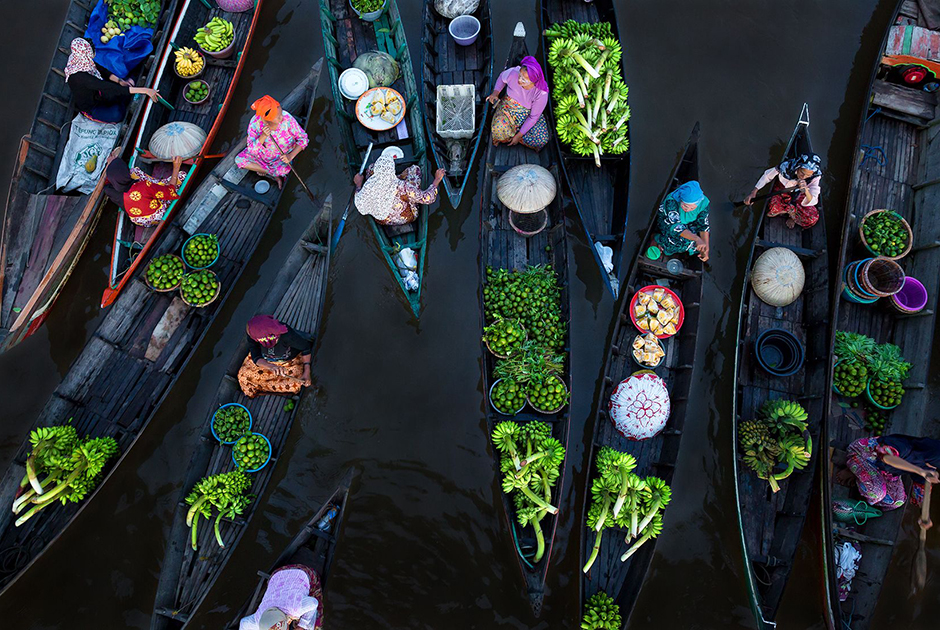 Ранним утром перед восходом солнца на красочном плавучем рынке Lok Baintan в Индонезии встречаются до ста лодок. Это один из старейших рынков в Азии, где жители до сих пор торгуют традиционными деревянными лодками.