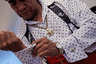 Хосе де Хесус Гонсалес де ла Роса вставляет запонки в свою рубашку. Этот житель Мехико один из тех, кто одевается в стиле пачукос не только на танцы, но и в повсденевной жизни. Для Хосе стиль пачукос — это предмет национальной гордости и идентичности, а также форма протеста против притеснений мексиканских мигрантов в США. 
