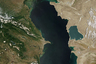 Вид Каспийского моря из космоса. На нем хорошо видно, что в северной части озеро зеленеет из-за водорослей. Дело в том, что соленость Каспия неравномерная: от 0,1 промилле неподалеку от дельты Волги до 11-13 промилле в юго-восточной части озера. 