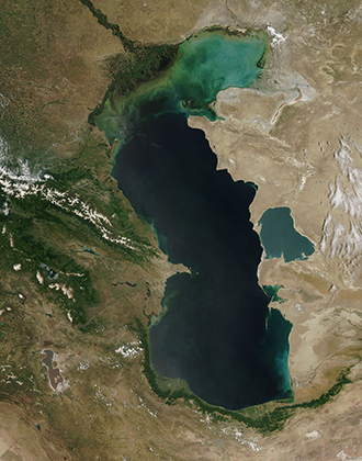 Вид Каспийского моря из космоса. На нем хорошо видно, что в северной части озеро зеленеет из-за водорослей. Дело в том, что соленость Каспия неравномерная: от 0,1 промилле неподалеку от дельты Волги до 11-13 промилле в юго-восточной части озера. 