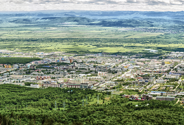 Вид на региональный центр Сахалинской области город Южно-Сахалинск с высоты окрестных сопок. Город отличает низкоэтажная застройка и большой частный сектор. 