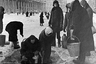 Жители блокадного Ленинграда набирают воду, появившуюся после артобстрела в пробоинах в асфальте на Невском проспекте.

