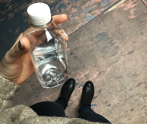 Бутылка воды в руке. Флакон в руке. Стеклянная бутылка в руке. Вода Эстетика в бутылке.