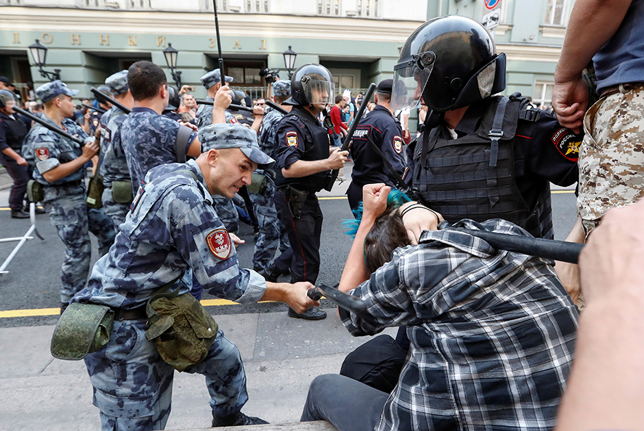 Полицейские бьют протестующего на митинге против запланированного повышения пенсионного возраста.