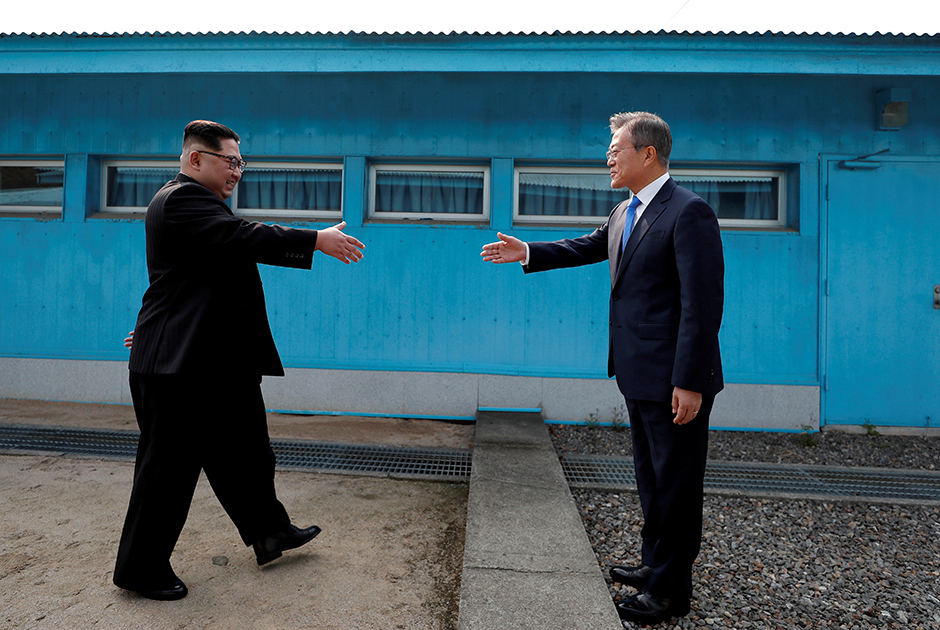 Лидеры Северной и Южной Корей — Ким Чен Ын и Мун Чжэ Ин — готовятся пожать руки на демаркационной линии в пограничной деревне Пханмунджом.