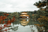 November 13th, 2015. Kyoto, Japan. The Golden Temple reflecting off a lake with a background of foliage. - Изображение