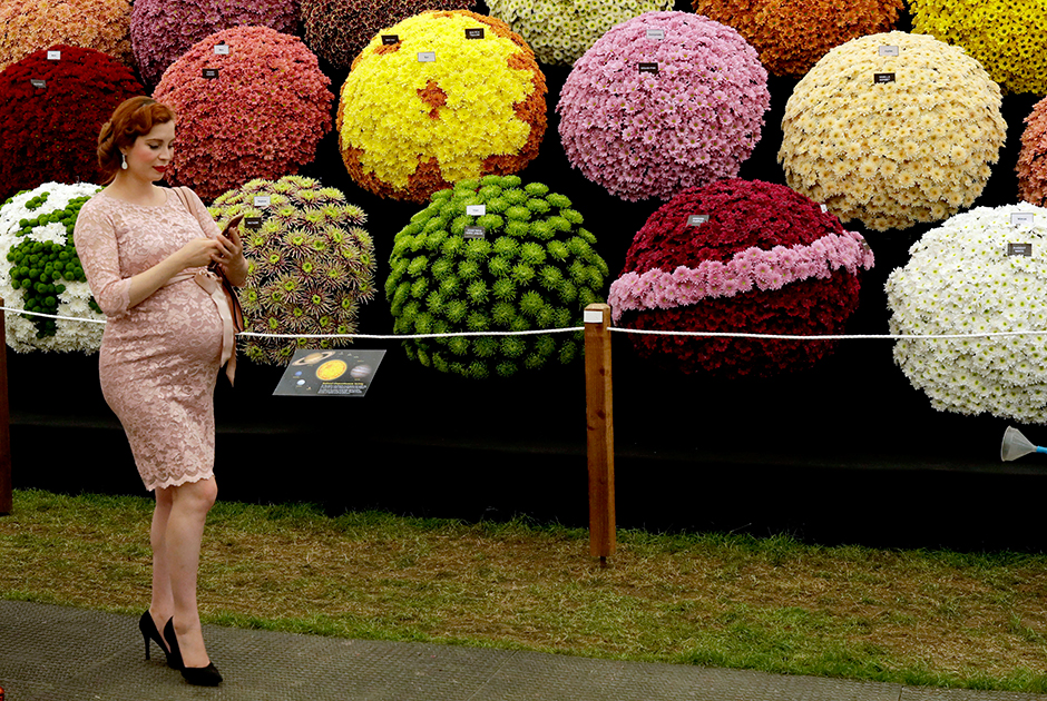 Женщина на фоне цветочной экспозиции Национального общества хризантем на выставке Chelsea Flower Show в Лондоне. Мероприятие организовано королевским садоводческим обществом и считается самой престижной выставкой в цветочном мире.