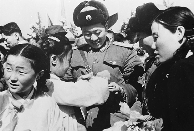 Корейская девочка дарит цветы уходящему из страны китайскому солдату. 1958 год