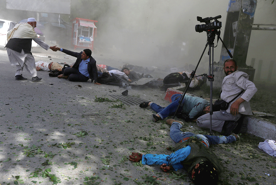 Кабул, Афганистан, 30 апреля 2018 года. Террорист-смертник подорвал взрывчатку, пока журналисты освещали взрыв у центра регистрации избирателей, произошедший незадолго до этого. 


Фотограф Reuters Омар Собхани вспоминает: «Было около 8:30 утра, место первого взрыва охраняли силовики, на работу собралось довольно много людей, и мы просто ждали вместе с другими журналистами. Затем мы услышали громкий взрыв прямо позади. Я выжил, потому что стоял перед бетонной колонной, которая защищала меня от силы взрыва, но я видел своих друзей и коллег на земле, многие из них были мертвы, а несколько ранены». Среди погибших был глава штаба фотографов агентства AFP в Афганистане.


Собхани ранило, но прежде, чем пойти за помощью, он сделал несколько снимков, в том числе этот. «Я был в шоке, но я видел, что ничего нельзя было сделать, и я сделал несколько снимков непосредственно перед уходом», — объясняет фотограф.


Собхани тяжело перенес произошедшее: «Это нелегкая работа. Вы постоянно видите войну и насилие, но важно донести это до людей. Я был очень шокирован — среди погибших были мои коллеги, а один из них был очень хорошим другом».
