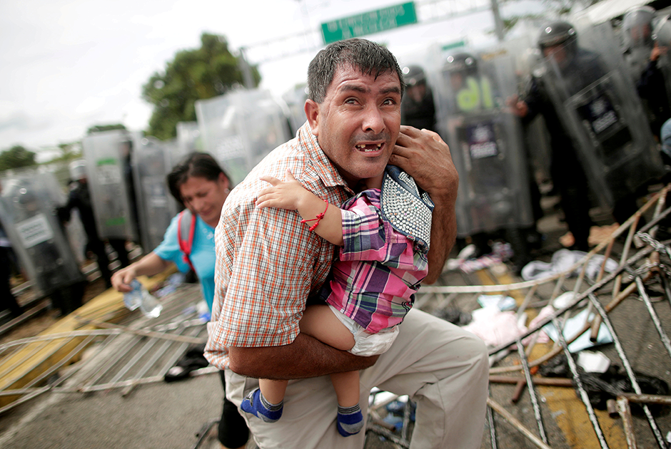 Мигрант из Гондураса пытается защитить своего ребенка во время штурма гватемальского пограничного пункта, который открывает путь в Мексику. На мексиканской стороне мигранты наткнулись на мощное сопротивление со стороны полиции, которая использовала для разгона газ. Штурм захлебнулся и закончился хаосом и замешательством. Фотограф признался, что произошедшее очень на него повлияло. 


«Я также являюсь отцом девятилетней девочки. Невозможно было не думать о том, что отец попал в такую паническую ситуацию. После того как я сделал эту фотографию, я вывел другие семьи за ограничительный полицейский кордон», — вспоминает автор снимка. 


Гондурасцы так и не смогли проникнуть в Мексику. Полиция все же оттеснила их на гватемальскую сторону.
