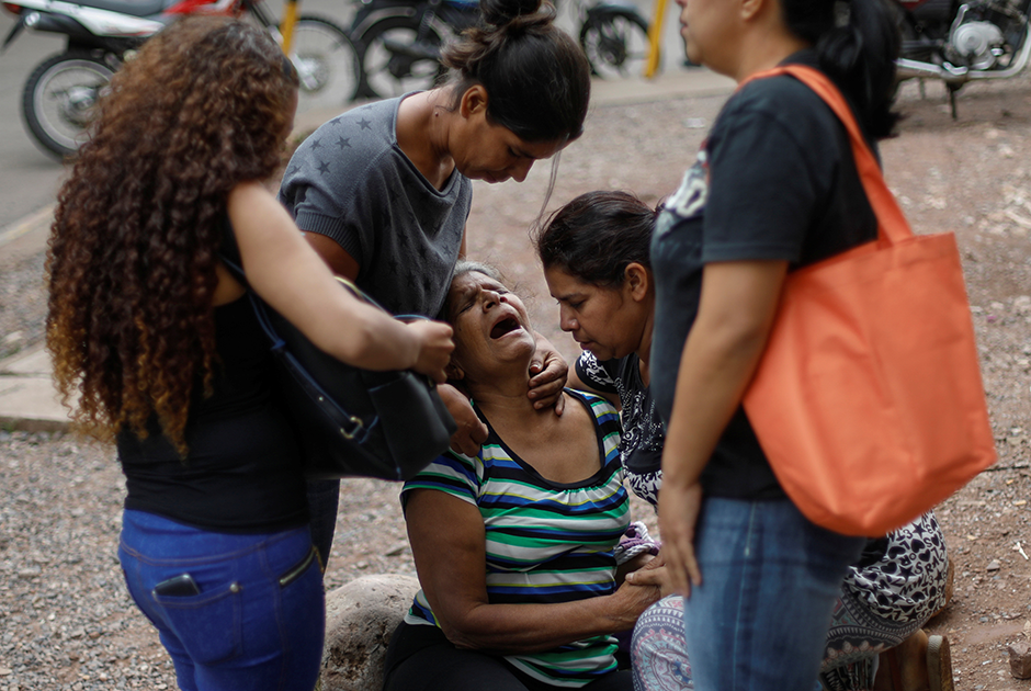 Женщина плачет на похоронах мужчины, который, по версии полиции, был похищен и убит
