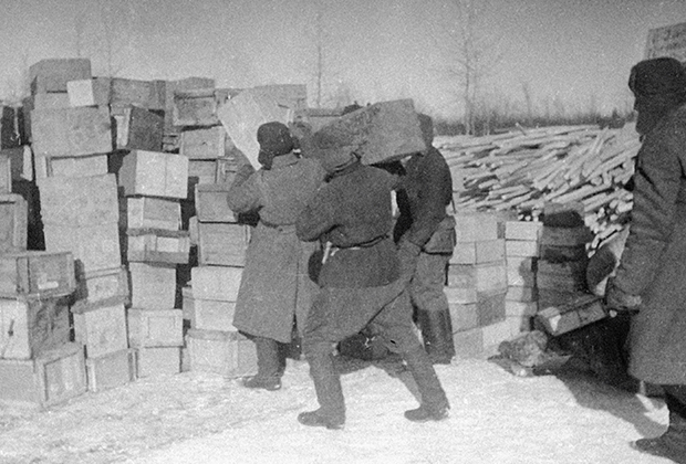 Солдаты разгружают ящики с продовольствием на складе на Ладожском озере во время блокады Ленинграда