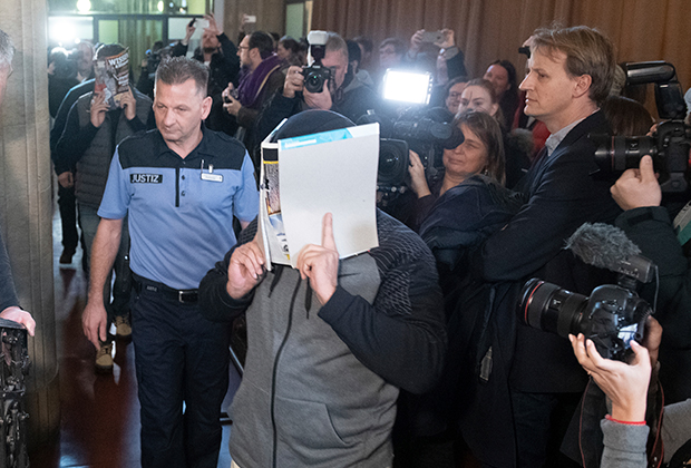 Обвиняемый прикрывает лицо на пути в суд. Берлин, 10 января 2019 года.