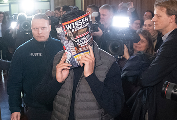 Обвиняемый прикрывает лицо на пути в суд. Берлин, 10 января 2019 года.