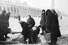 Жители блокадного Ленинграда набирают воду, появившуюся после артобстрела в пробоинах в асфальте на Невском проспекте. Декабрь 1942 г. 