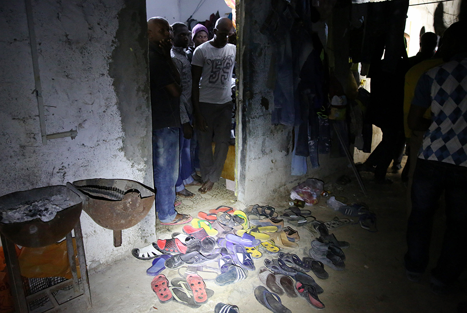 Африканские мигранты столпились во время рейда полиции в здании на окраине Триполи. 