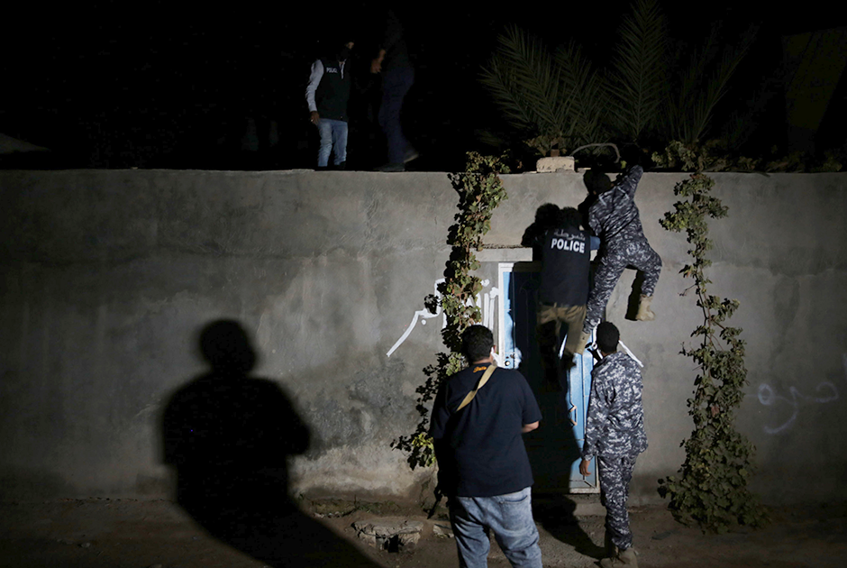 Сотрудники миграционного отделения ливийской полиции совершают налет на здание, где прячутся африканские мигранты. 