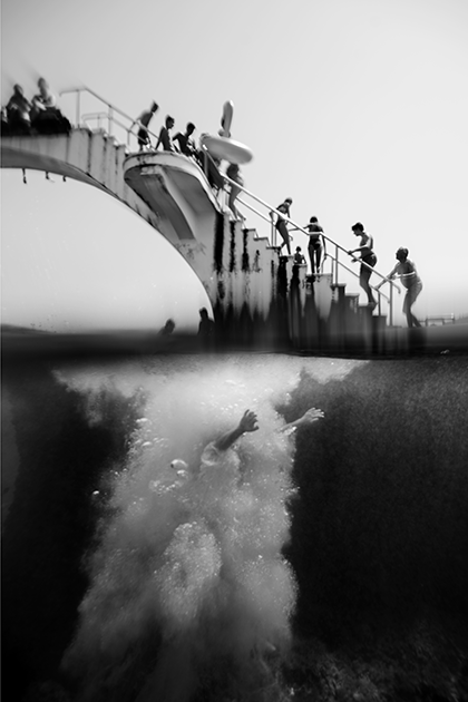 Грек Филиппос Алафакис запечатлел на своем снимке «Руки» момент сразу после прыжка мужчины с трамплина на одном из многолюдных пляжей острова Родос.  