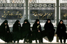 Женщины ждут автобус на остановке в Мешхеде — втором по размерам городе Ирана, который считается религиозной столицей страны. Многие современные иранки закрывают все, кроме лица, и носят исключительно одежду черного цвета. Фотография сделана в 2008 году. 