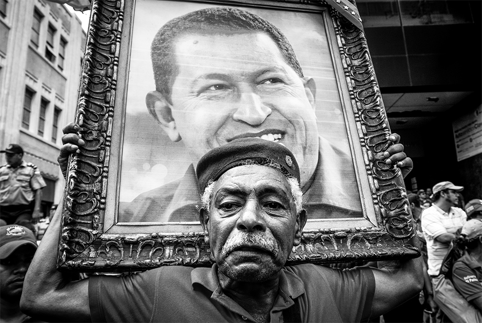 «Состояние распада» — так фотограф Алехандро Чегарра, документирующий жизнь в Венесуэле, охарактеризовал ее нынешнее положение. При Уго Чавесе страна пережила небывалый экономический подъем в истории. При его преемнике Николасе Мадуро государство находится в небывалом упадке. Гиперинфляция усугубилась санкциями со стороны США. Из-за растущей нехватки продовольствия, лекарств и предметов первой необходимости обострилась политическая напряженность, которая вылилась в уличные протесты. Фотограф наблюдает за тем, как меняется Венесуэла после смерти Чавеса в 2013 году. Его работа номинирована в категории «Долгосрочные проекты».




