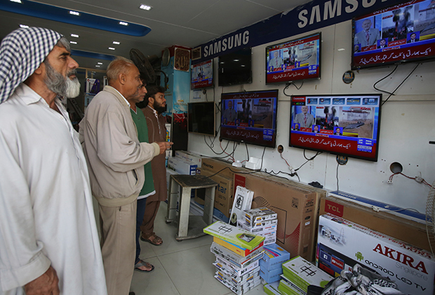 Пакистанцы смотрят новости в городе Карачи