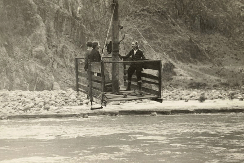 Три женщины пересекают реку Колорадо с помощью канатной дороги с ручным приводом. Около 1935 года. 

