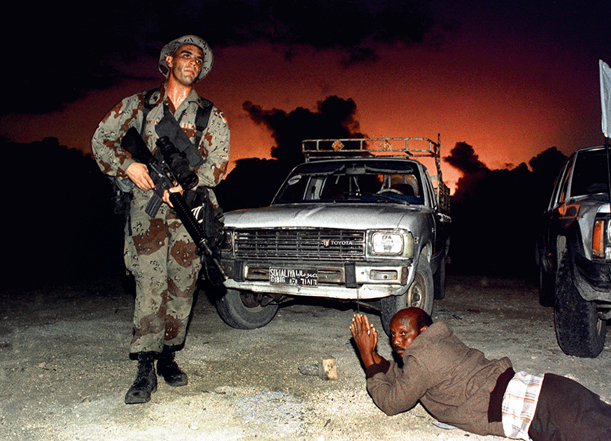 Морские пехотинцы США обеспечивают безопасность в порту Могадишо во время десантной операции «Возрождение надежды» в Сомали: местному водителю приказано лечь на землю. 9 декабря 1992 года. 