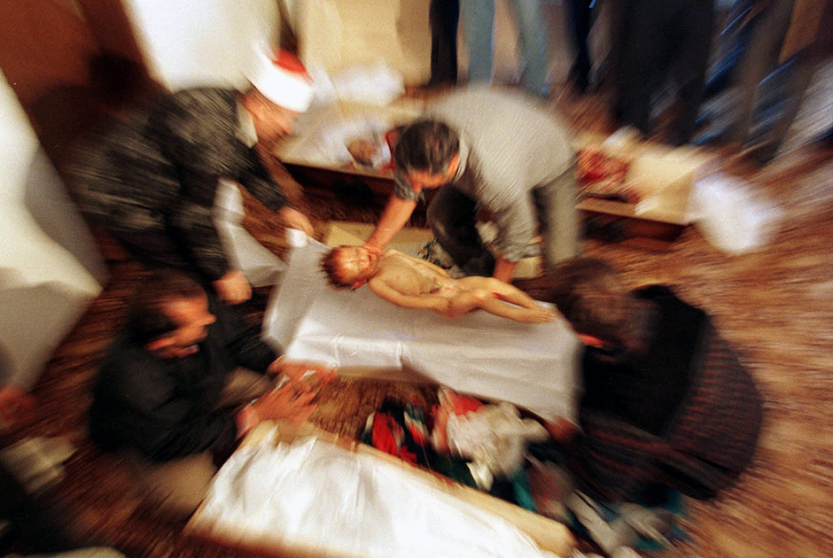 Этнический албанец помещает тело двухлетнего Моззлума Сильметая в гроб. Рядом с ним — гробы трех других членов семьи, убитых военными югославской армии во время перехода в Косово из Албании. Семья бежала от войны и насилия, но после сообщений о заключении мирного соглашения решила вернуться в родную албанскую деревню. 
