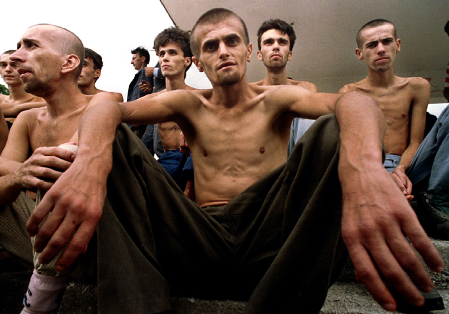 Группа изможденных мусульман, недавно освобожденных из хорватского концентрационного лагеря в Дретеле, ждет свой обед в средней школе в городе Ябланица. За время, проведенное в заключении, каждый из них потерял более 20 килограммов.