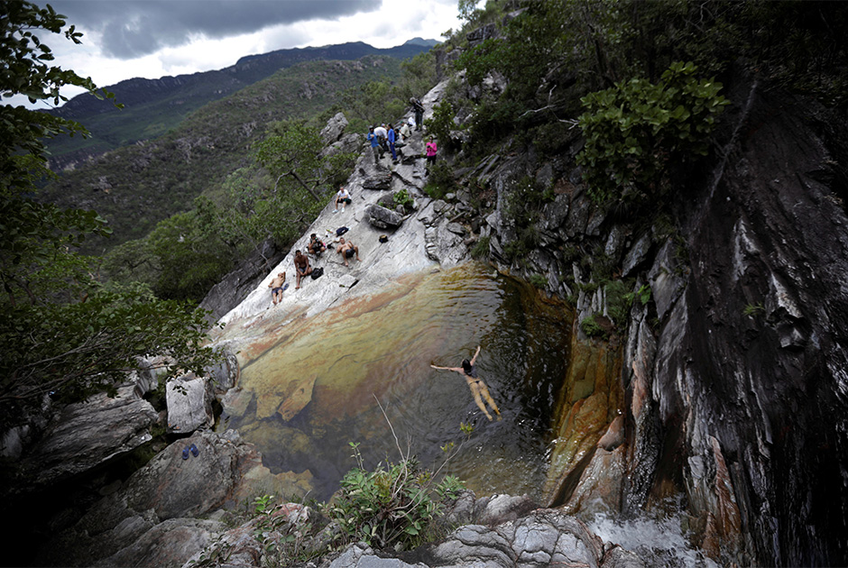 Посетители бразильского Национального парка Chapada dos Veadeiros купаются в водопаде.


