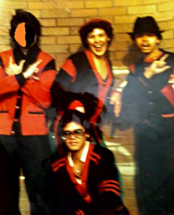 Участники уличной банды Warlords позируют на фоне стены собственной школы в черно-красных свитерах своей группировки. Фото 1979 года.