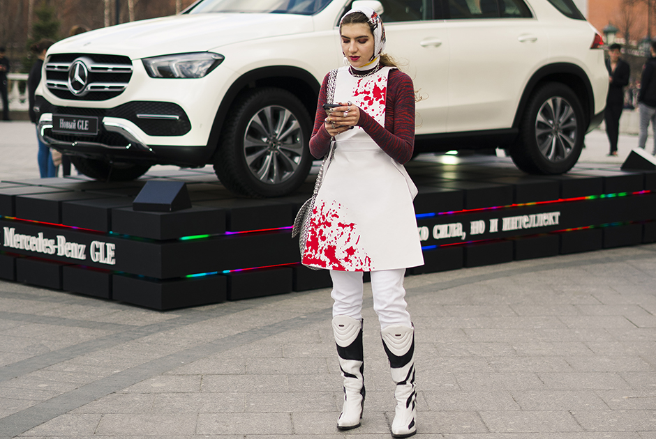 Гостья Mercedes Benz-Fashion Week Russia оригинально сочетает скромную косыночку с сапогами в стиле мотогонщиков и платье с бутафорскими брызгами крови.