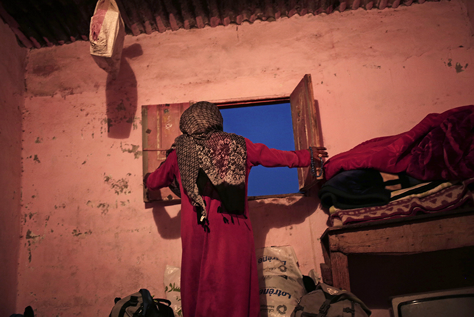 Умм Яссер закрывает окно в своем доме. Бедуинские деревни, расположенные в глубине Синайского полуострова, остались вдали от туристических маршрутов и курортов побережья. Их жители страдают от безработицы и живут в нищете. 