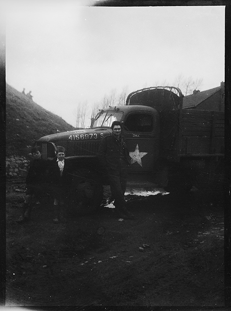 Портрет водителя американской армии вместе с детьми возле армейского грузовика. Нидерланды, 1944 год.